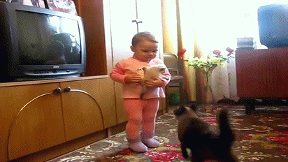 Une mère chat qui récupère son chaton dans les bras d'une petite fille